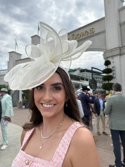 Smiling portrait with fascinator and diamond pendant necklace at Churchill Downs
